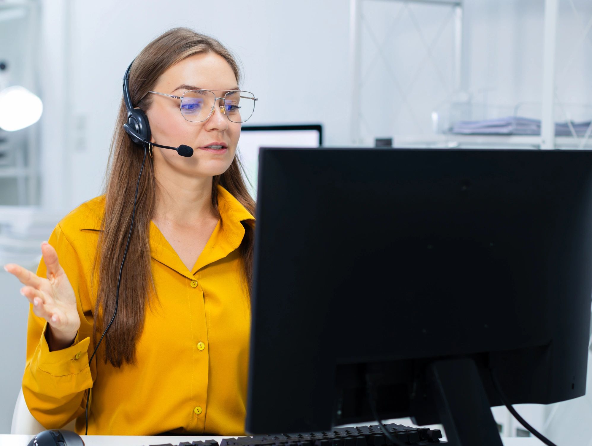 Customer support agent using a headset in a modern office
